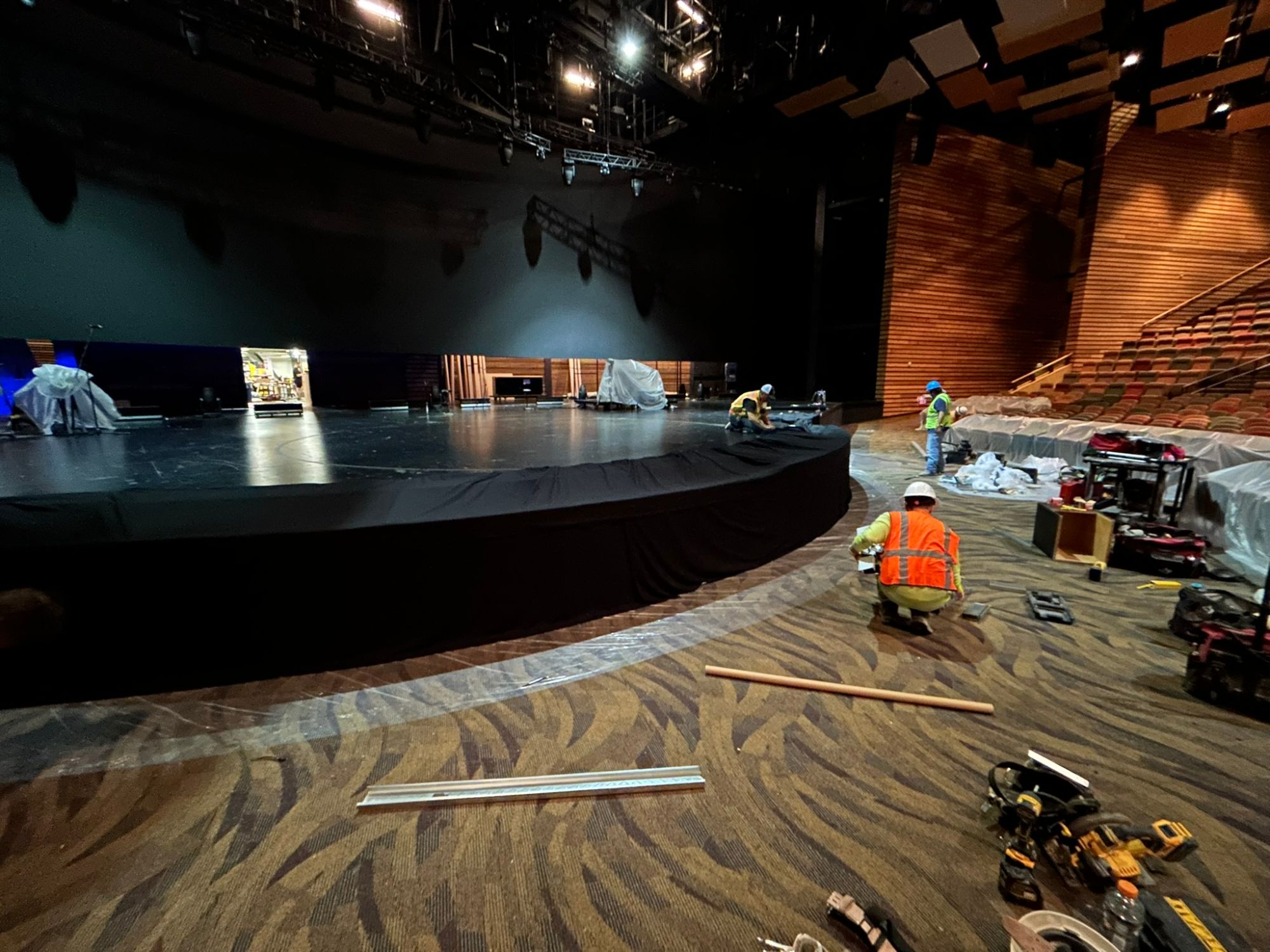 Crews finishing a theater stage and floor during renovation